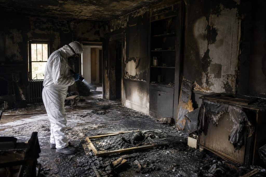 Restoration worker assessing fire and smoke damage in a Houston home